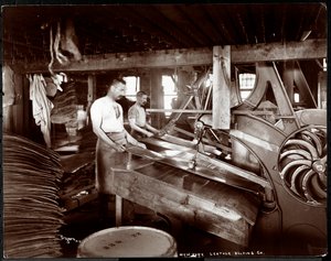 Indvendigt billede af to mænd, der arbejder med læder og tungt udstyr på New York Leather Belting Co. i New York, New York, 1905 (sølvgelatineprint)